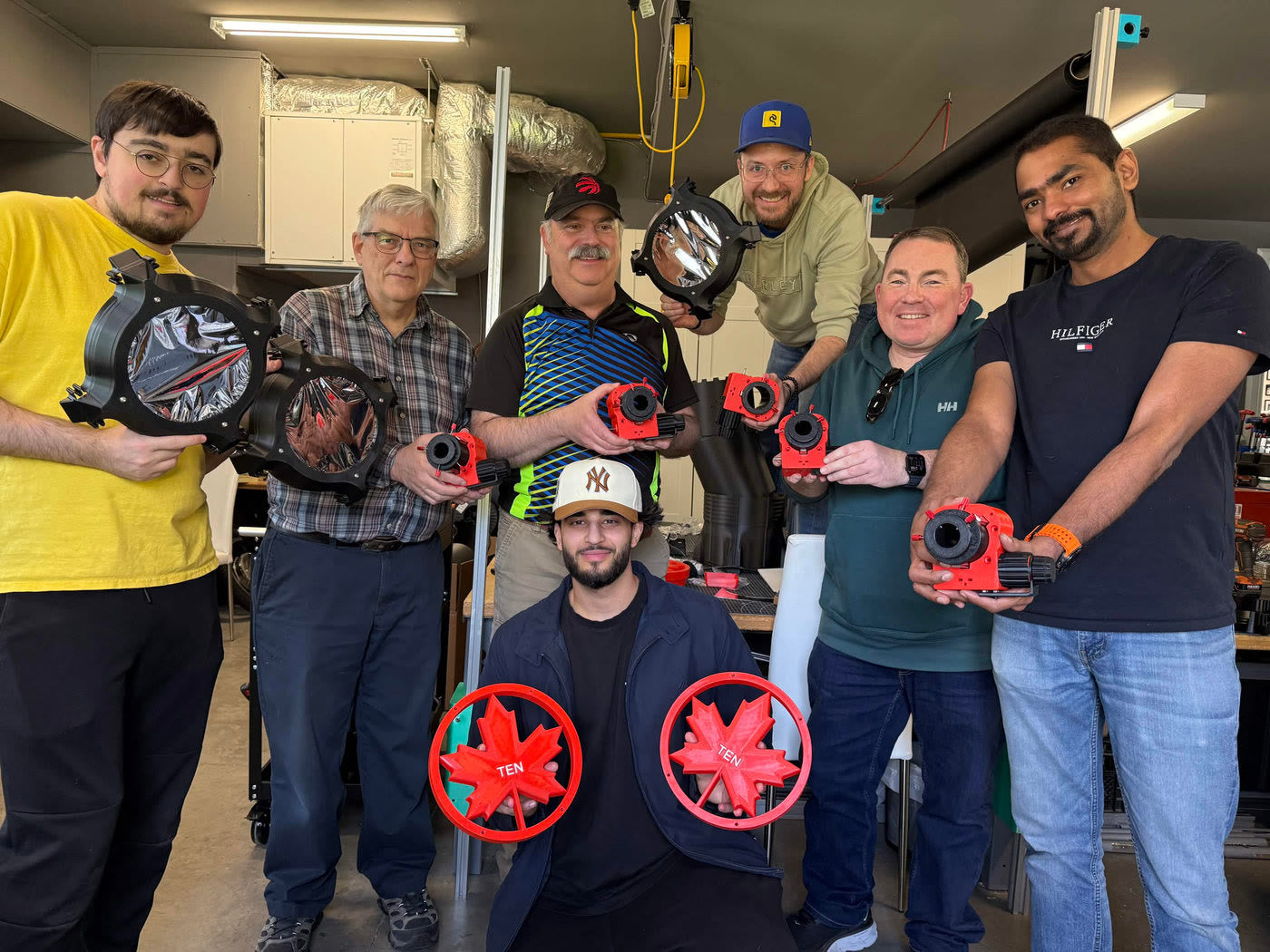 Volunteers holding freshly assembled red Skyward 200 components