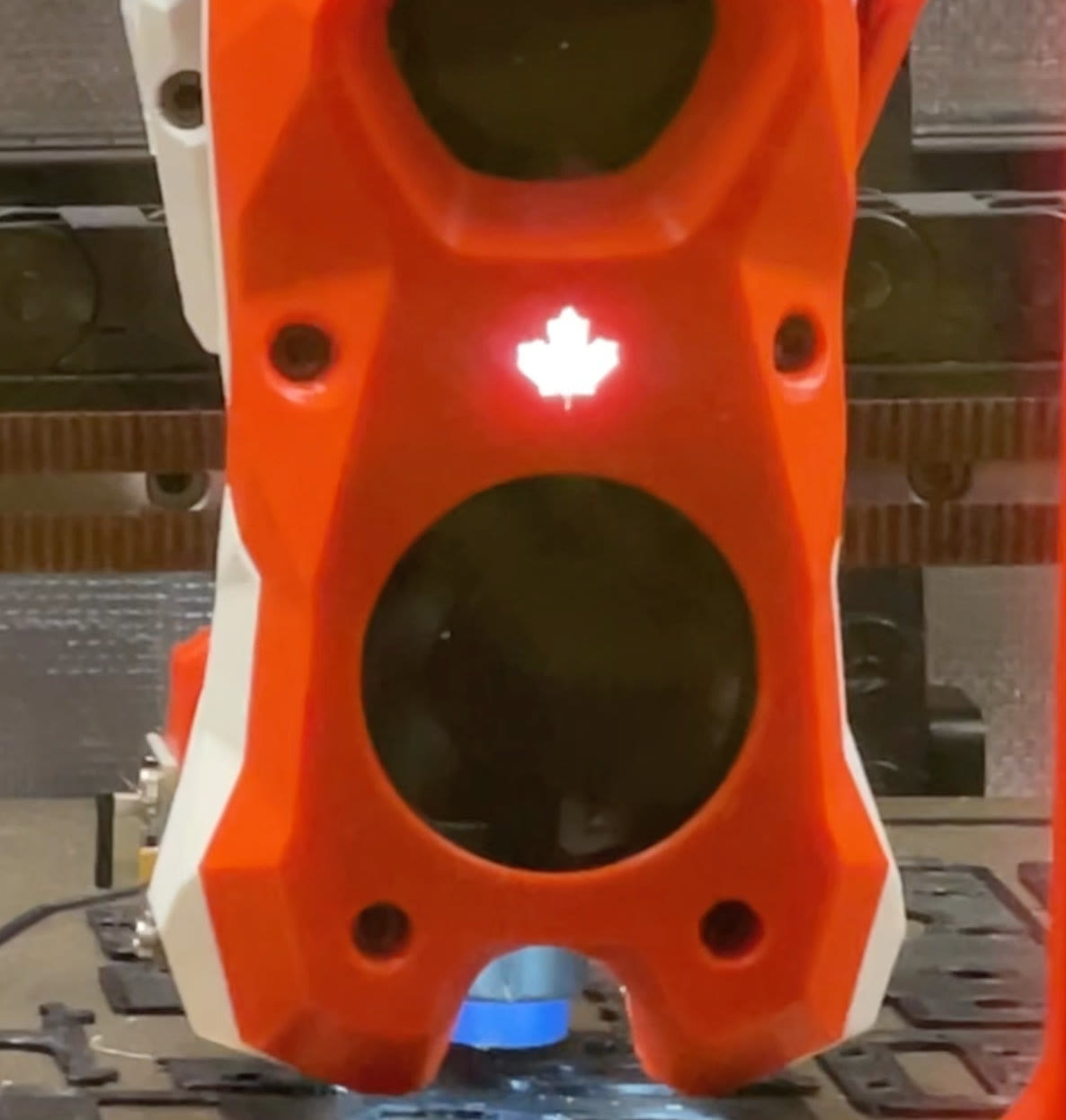 Orange printed toolhead with a glowing maple leaf on a custom printer