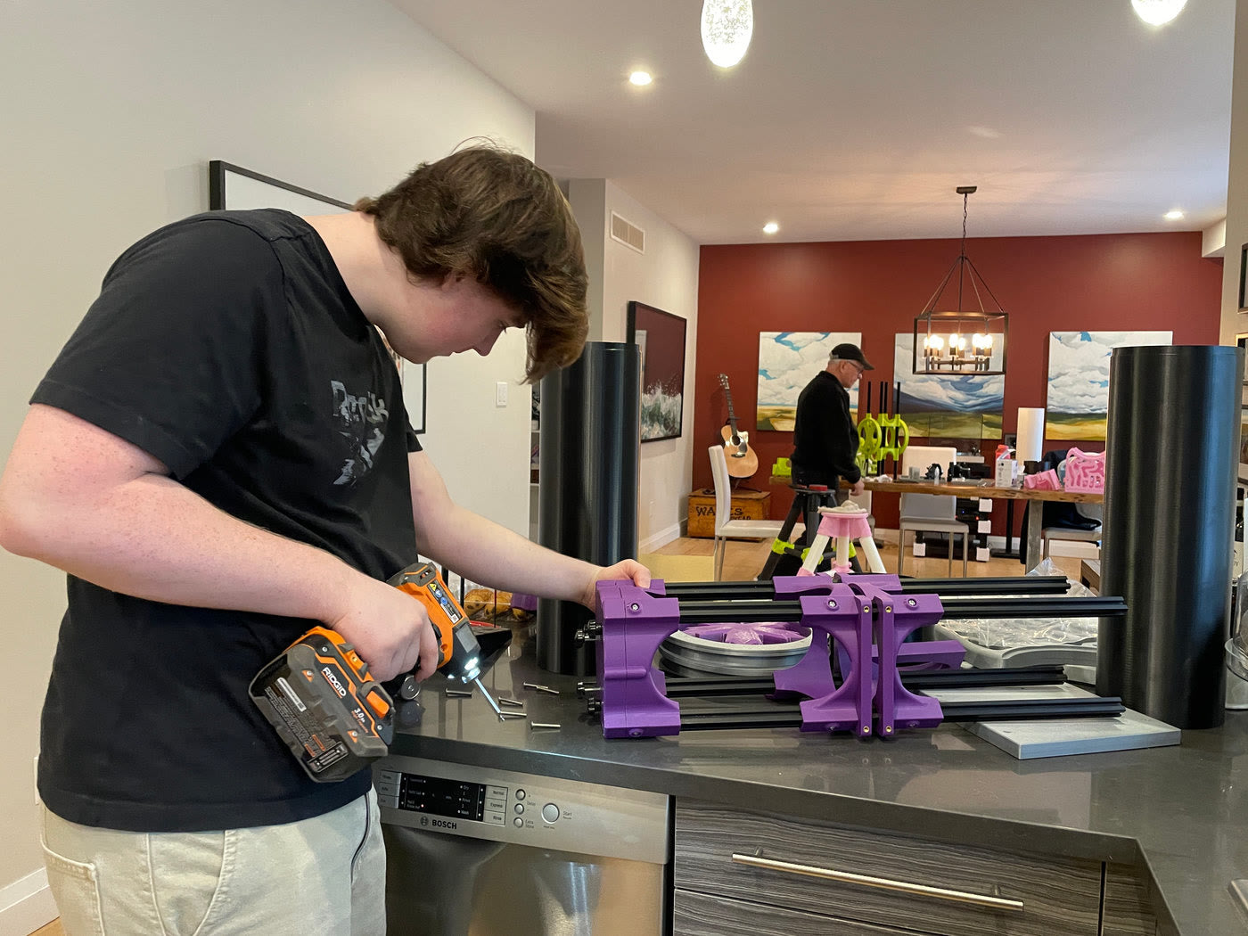 Volunteer building a purple rocker box with a drill
