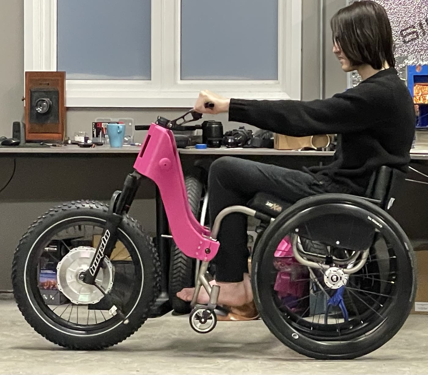 Rider using a pink printed drive unit attached to a manual wheelchair