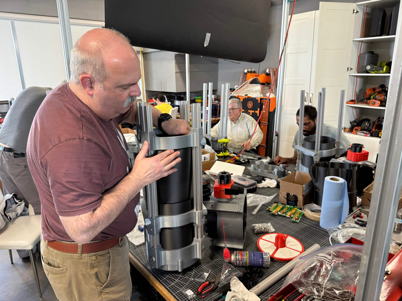 Volunteer assembling an optical tube at the workbench